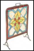 A 19th Century Victorian stained lead glass and brass surround fire screen, the centre designed as a