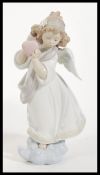 A Lladro ceramic figurine entitled ' Loving The World '  depicting an angel with flowers to hair