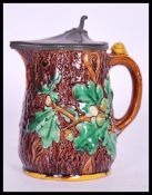 A 19th Century Victorian Majolica oak jug having a tree bark effect to the exterior with raised