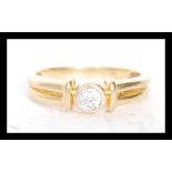 A stamped 18ct gold solitaire ring bezel set with a brilliant cut diamond. Weight 2.6g. Diamond