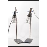 A pair of vintage retro 20th Century inspection lamps having wire cages mounted on Griffin and