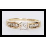 A hallmarked 9ct gold ring having a central square illusion set diamond with diamond set