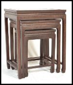 A 20th Century nest of three graduated Chinese hardwood occasional tables of simple form raised on