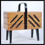 A vintage retro 20th Century beech wood work / sewing box with a concertina action, ebonised carry