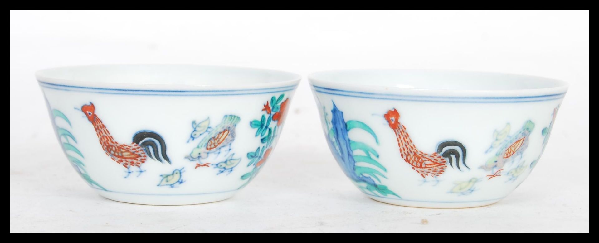 A pair of 20th Century Chinese porcelain tea bowls decorated in Wucai colours cockerels, chickens