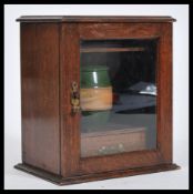 A 19th Century Victorian oak smokers cabinet having a twin glazed door complete with stoneware