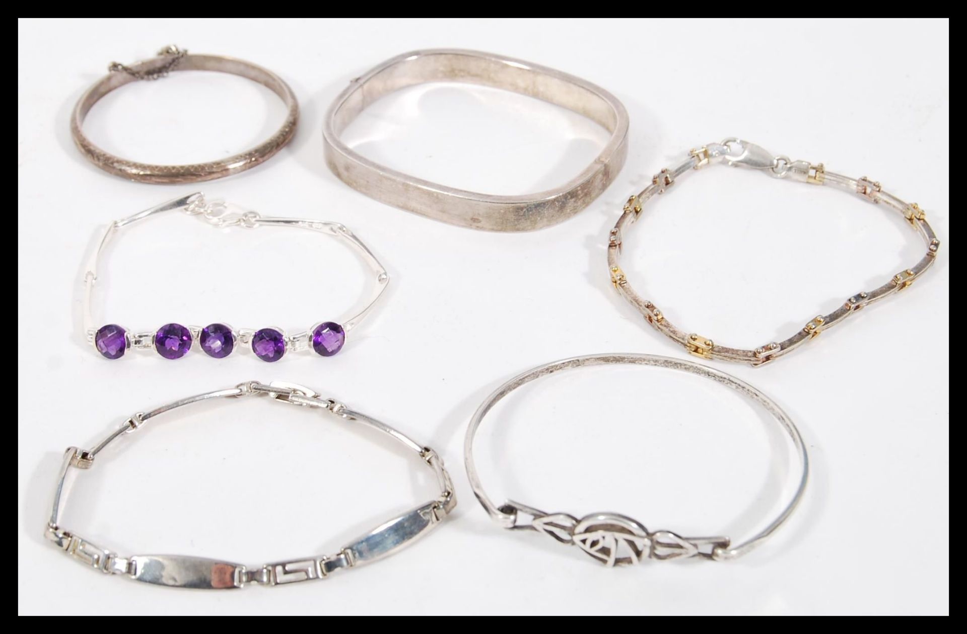 A selection of silver bracelets to include a square bangle with a hinge opening, a child's bangle