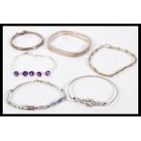 A selection of silver bracelets to include a square bangle with a hinge opening, a child's bangle