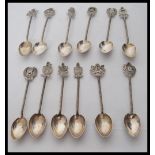 A collection of silver souvenir tea spoons having engraved crest finials with twisted shanks. Marked