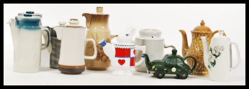 A collection of 20th Century vintage and novelty tea and coffee pots to include two Wedgwood blue