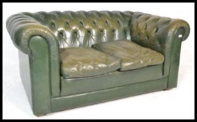 A Chesterfield two seater button back sofa settee raised on bin feet with scrolled arms