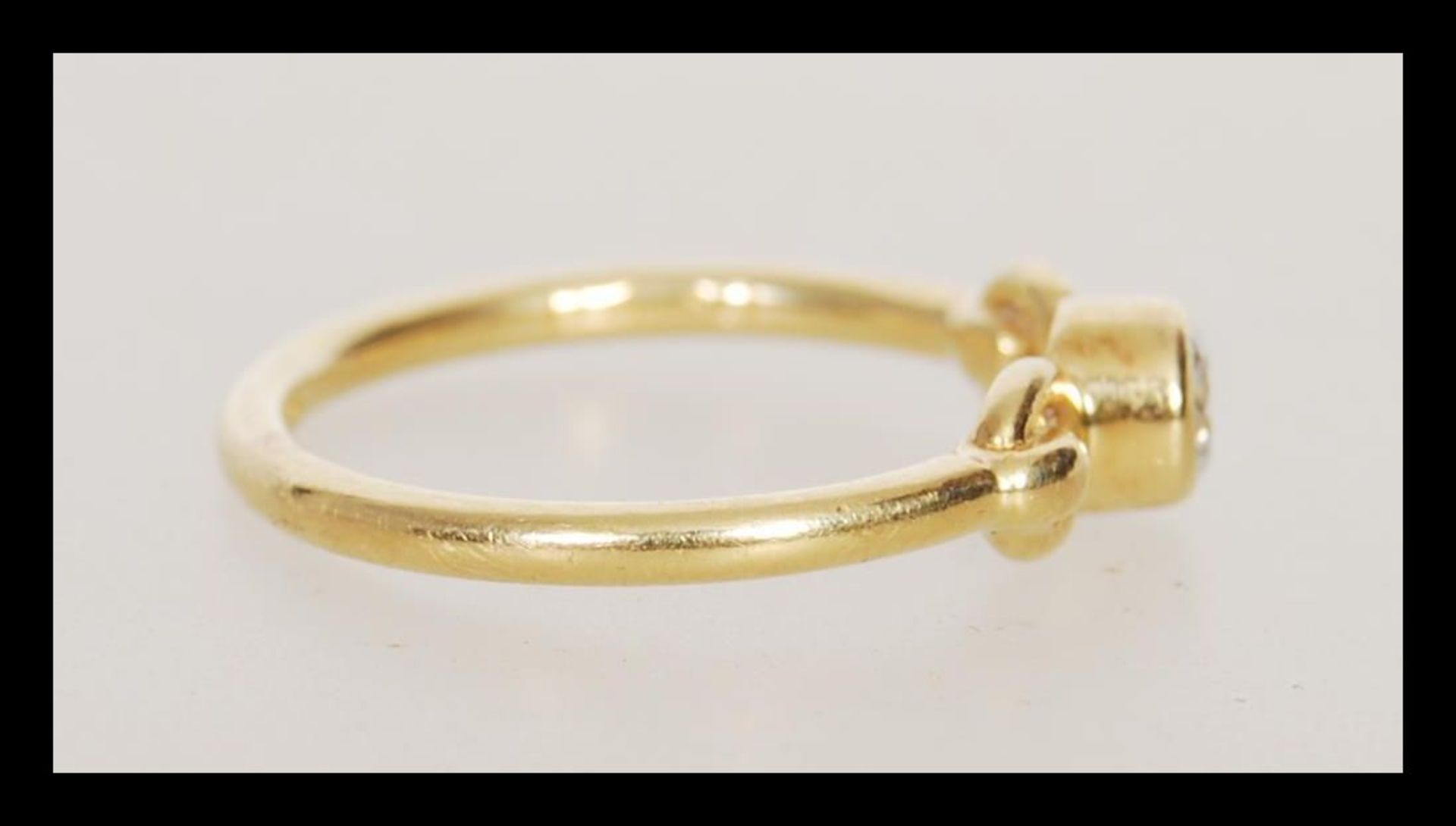 A hallmarked 18ct gold ring set bezel set with a brilliant cut diamond with decorative looped - Bild 2 aus 4