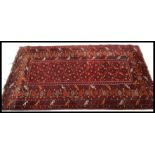 An early 20th Century Persian Islamic Middle Eastern runner carpet rug having a red ground with