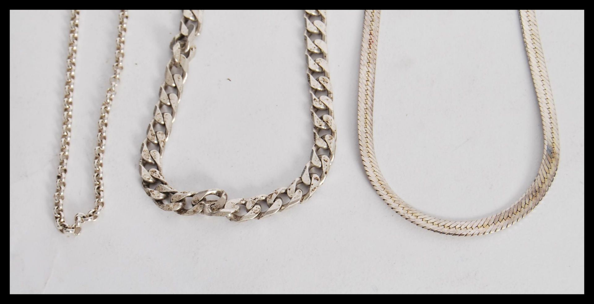 Three stamped 925 silver necklaces to include a flat linked snake chain, a flat linked necklace with