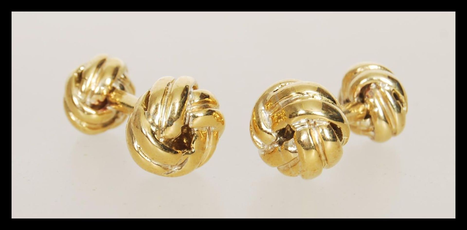 A pair of 18ct gold plated cufflinks having knot design heads. Measures 2cm wide.