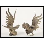 A pair of early 20th Century silver plated fighting cocks fireside figurines depicting two cockerels