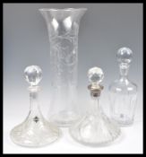 A collection of cut glass to include decanters and a tall glass vase in the manner of Thomas Webb.