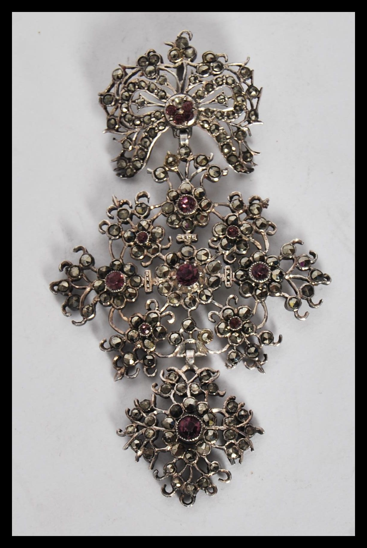 A late 19th / early 20th Century silver pendant, set with marcasites and pink paste in a floral