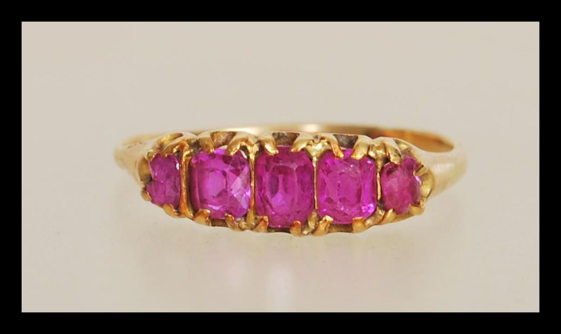 An early 20th Century 18ct gold ring prong set with five rectangular cut pink stones. Unmarked but