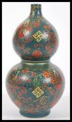 A 20th Century Chinese porcelain double gourd vase having a deep teal ground with hand enamelled red