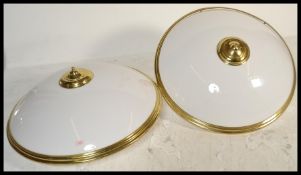 A pair of large circular flush ceiling lights with gilt metal fixtures and domed frosted perspex