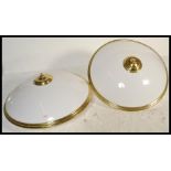 A pair of large circular flush ceiling lights with gilt metal fixtures and domed frosted perspex