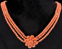 A vintage 14ct gold and coral three strand necklace. The necklace having a large coral cluster