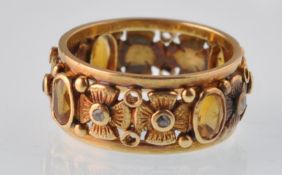 An unusual early 20th century continental gold citrine and rose diamond broad band ring. The oval