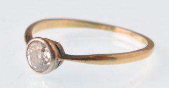An early 20th century gold and diamond solitaire ring. The old cut stone approx 0.60cts in a rub