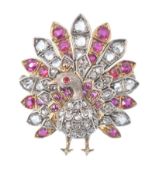 A gold diamond, ruby and red stone figural brooch.  The brooch in the form of a peacock set with old