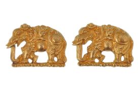 A pair of gold elephant pendants. The elephants made in high relief, possibly part of a larger