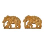 A pair of gold elephant pendants. The elephants made in high relief, possibly part of a larger