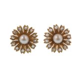 A pair of gold pearl and diamond earrings. The earrings being designed in the form of a flower