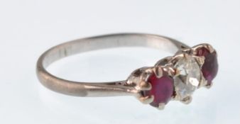 An early 20th century platinum ruby and diamond 3 stone ring. The central old cut diamond approx 0.