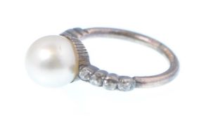 A 19th century gold, silver, pearl and diamond ring. The ring being set with a central large pearl