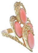A 1970's French 18ct gold and coral wishbone ring. The ring being set with four oval coral