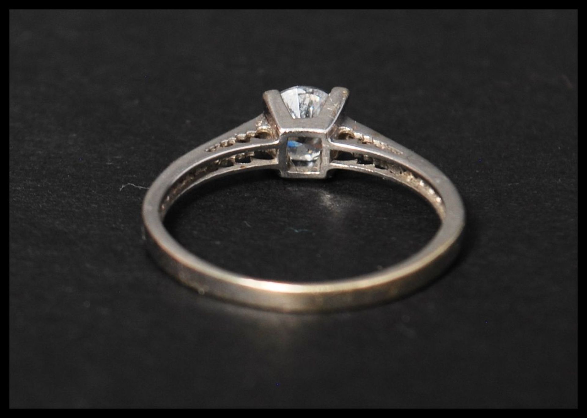 A hallmarked 9ct white gold and CZ ring having a central round cut  CZ with CZ set shoulders. - Bild 3 aus 4
