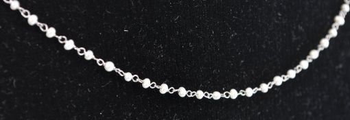 A platinum and pearl chain necklace. The necklace consisting of fine delicate pearl and chain