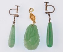 A Chinese gold and Jadeite pendant. The drop shaped Jadeite carved with fruits and leaves and