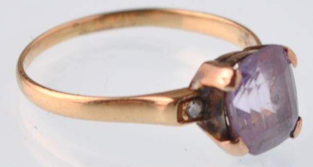 An 18ct gold purple sapphire and diamond dress ring. The violet cushion shaped stone being claw
