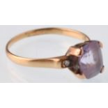 An 18ct gold purple sapphire and diamond dress ring. The violet cushion shaped stone being claw