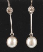 A pair of white gold, diamond and pearl earrings. The earrings having collet set brilliant cut