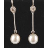 A pair of white gold, diamond and pearl earrings. The earrings having collet set brilliant cut