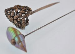 An early 20th century hat pin and hair stick pin. The hat pin completed with a shell finial, the