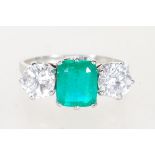 EMERALD AND DIAMOND WHITE GOLD THREE STONE RING.