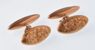 A pair of Edwardian 9ct rose gold gentleman's cuff links. Each with leaf engraved oval panel with