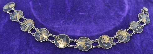 A signed vintage Japanese 14K damascene, shakudo bracelet. The bracelet having 10 scene links