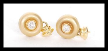 A pair of stamped 18ct gold stud earrings bezel se