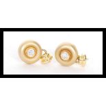 A pair of stamped 18ct gold stud earrings bezel se