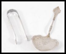 A set of silver sugar tongs having engraved garlan